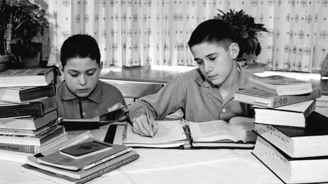 Two brothers doing their homework in a photo from around 1960. Two brothers doing their homework in a photo from around 1960.