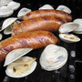 Chorizo and clams cooking on a grill