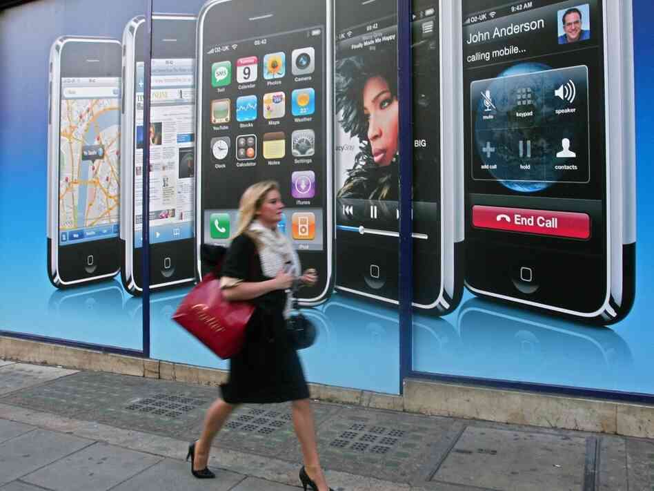 A woman walks by a new Apple location in London. Chen says the iPhone's reach has extended beyond the gadget market to impact all areas of our lives.