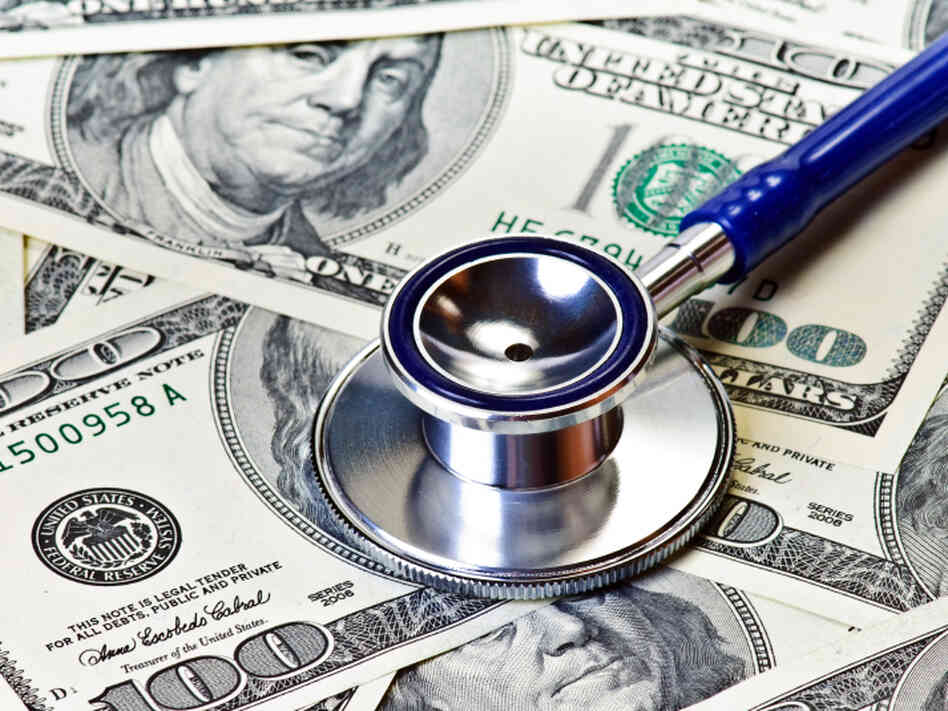 Stethoscope rests on $100 bills. Stethoscope rests on $100 bills.