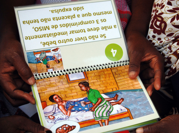 The birth attendants review a booklet on the use of misoprostol that has easy-to-understand illustrations.