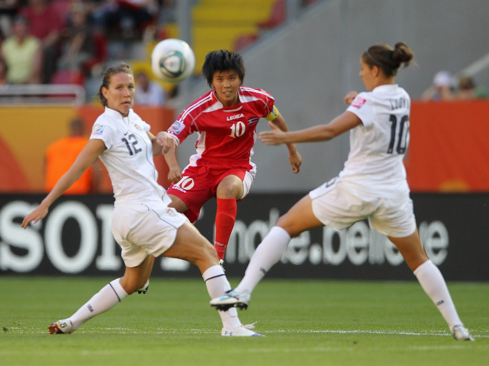 Lauren Cheney, left, and Carli Lloyd, right, of the U.S. battle for the ball with Yun Mi Jo of Korea DPR in their opening Group C match of the FIFA Women's World Cup at Rudolf-Harbig-Stadion in Dresden, Germany.