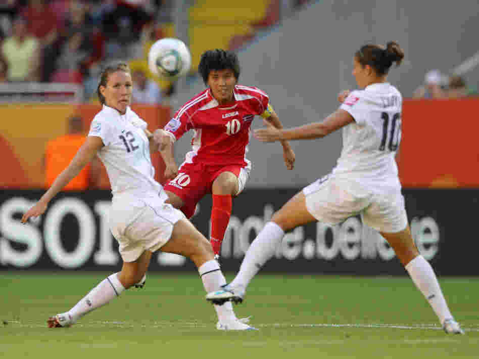 Lauren Cheney, left, and Carli Lloyd, right, of the U.S. battle for the ball with Yun Mi Jo of Korea DPR in their opening Group C match of the FIFA Women's World Cup at Rudolf-Harbig-Stadion in Dresden, Germany.