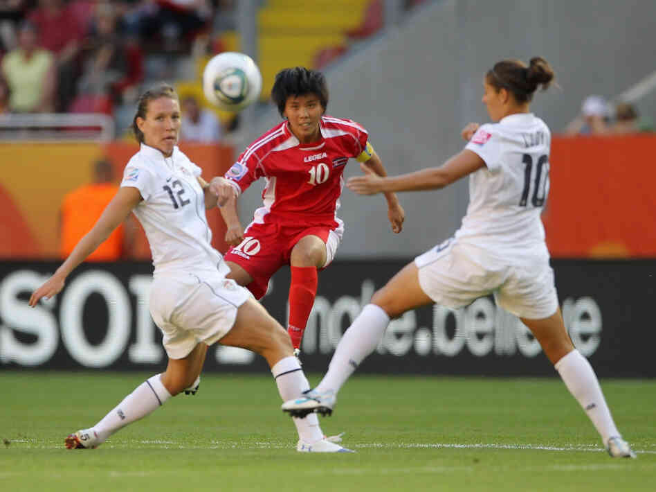 Lauren Cheney, left, and Carli Lloyd, right, of the U.S. battle for the ball with Yun Mi Jo of Korea DPR in their opening Group C match of the FIFA Women's World Cup at Rudolf-Harbig-Stadion in Dresden, Germany.