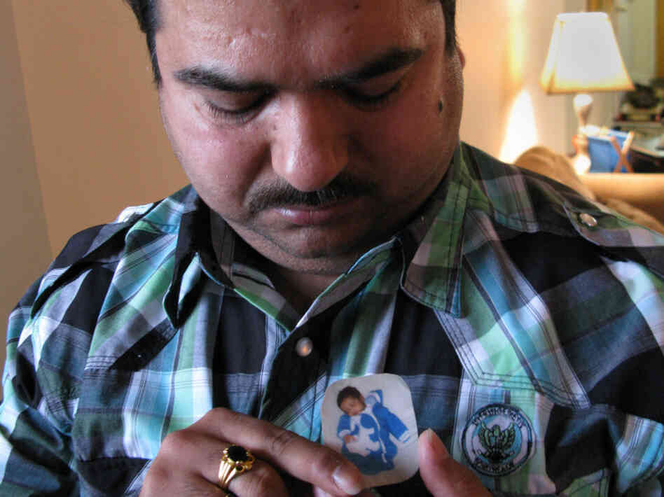 Dinesh Kumar looks down at a portrait of his son, who died when he was 5 weeks old. Dinesh Kumar looks down at a portrait of his son, who died when he was 5 weeks old.
