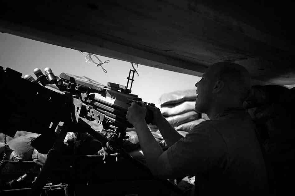 Spc. Gregory Goodrich, from Paw Paw, Mich., fires a Mark 19 grenade launcher at a Taliban mortar team as incoming rounds hit just outside the bunker at Combat Outpost Wilderness in Paktia province.
