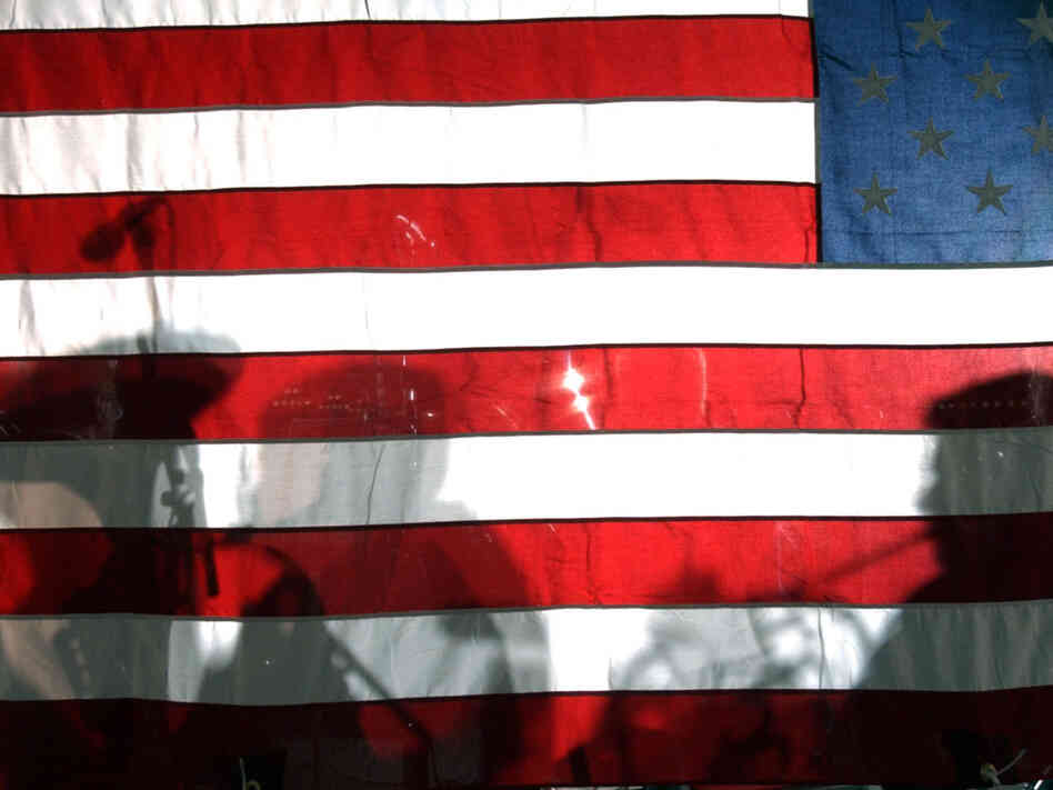 BOSTON, MA - SEPTEMBER 14: Shadows of musicians from the Boston Symphony Orchestra fall on the American flag during a performance. BOSTON, MA - SEPTEMBER 14: Shadows of musicians from the Boston Symphony Orchestra fall on the American flag during a performance.