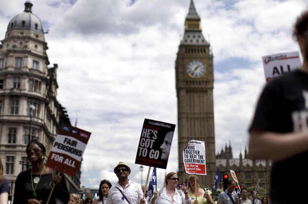 People march past the Houses of Parliament with placards as they take part in a protest to mark the nationwide day of strikes in London.