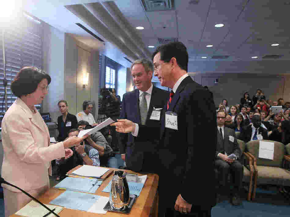 Comedian Stephen Colbert with his attorney, Trevor Potter, turns in a document at a Federal Election Commission hearing, June 30, 2011.