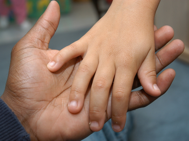 Dads feel stretched thin too. (A father and child hold hands.)