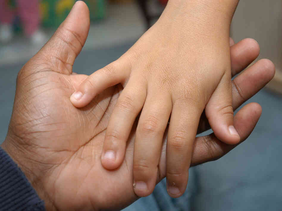 Dads feel stretched thin too. (A father and child hold hands.)