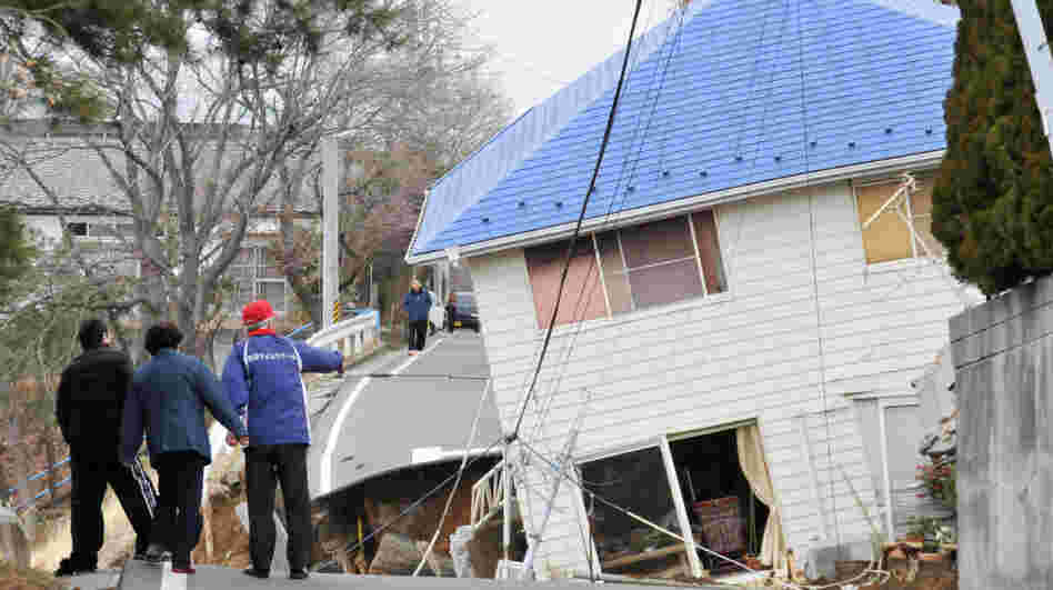 Residents check an earthquake-damaged house in Sukagawa city on March 11, in the Fukushima prefecture in Japan. A researcher says that after large-scale natural disasters, it's frequently friends and neighbors who are key to survival.