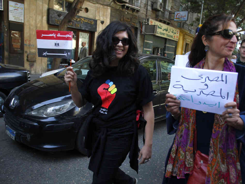 An Egyptian woman carries a banner that reads "Egyptian man and woman in one hand," on a march to Cairo's Tahrir Square to celebrate International Women's Day. The protest demanding equal rights and an end to sexual harassment turned violent when men verbally abused and shoved demonstrators, telling them they belong at home. An Egyptian woman carries a banner that reads "Egyptian man and woman in one hand," on a march to Cairo's Tahrir Square to celebrate International Women's Day. The protest demanding equal rights and an end to sexual harassment turned violent when men verbally abused and shoved demonstrators, telling them they belong at home.