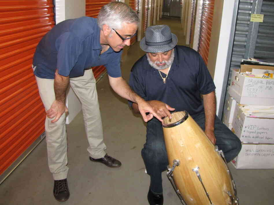 Attorney Kevin Costanza and drummer Poncho Sanchez examine one of Brando's patented conga-tuning devices.