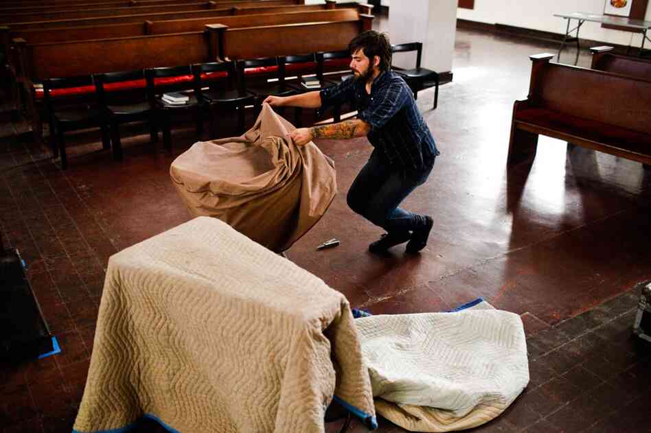 Isaac Jones, guitarist for Braveyoung, unpacks a tympani before the band's performance.