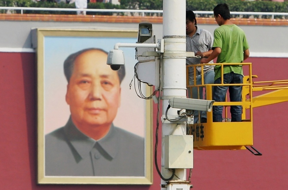 Chinese laborers adjust a surveillance camera at Tiananmen Square in 2007 in Beijing, China.