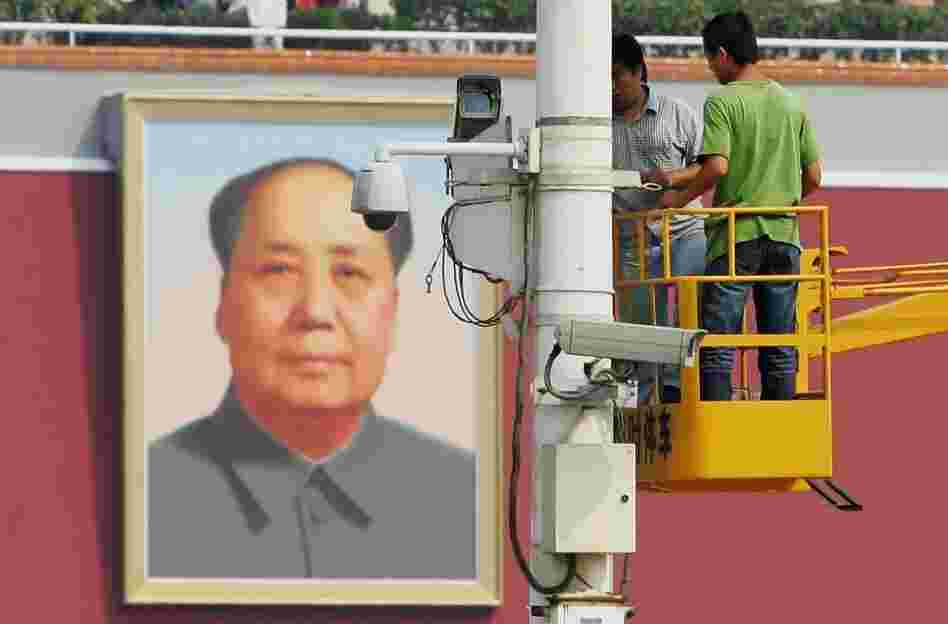 Chinese laborers adjust a surveillance camera at Tiananmen Square in 2007 in Beijing, China.