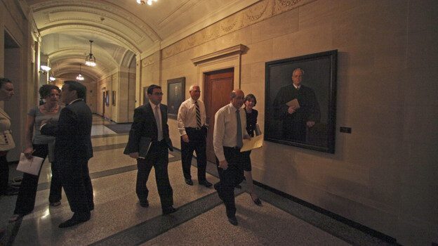Joseph Cassioppi, David Lillehaug, Solicitor General Alan Gilbert and Attorney General Lori Swanson enter a hearing room before testimony Tuesday at a hearing at the Minnesota Capitol in St. Paul.    The hearing focused on services that will receive emergency funding while a state budget impasse continues.