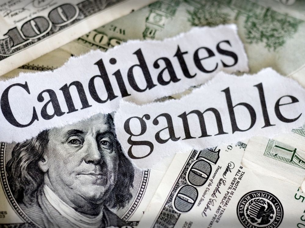 Hundred dollar bills with the words "candidates gamble."