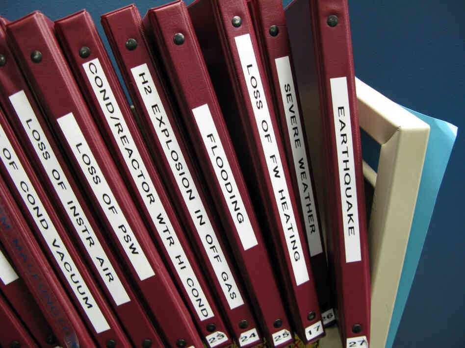 A shelf in the control room simulator holds binders of protocols for how to handle emergency situations.