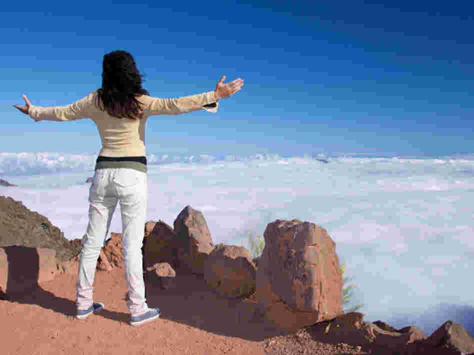 A woman celebrates her climb to the top.