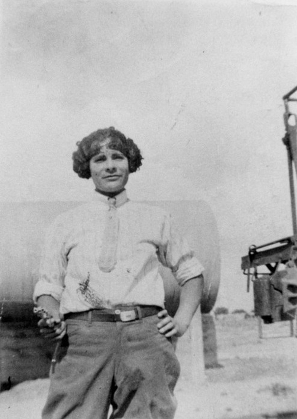 A woman wears pants and wields a gun in the 1920s.