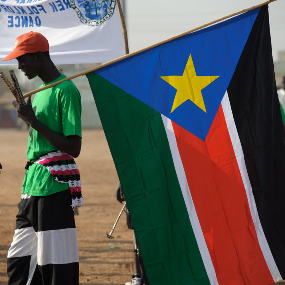 A Sudanese man holds the flag of South Sudan.