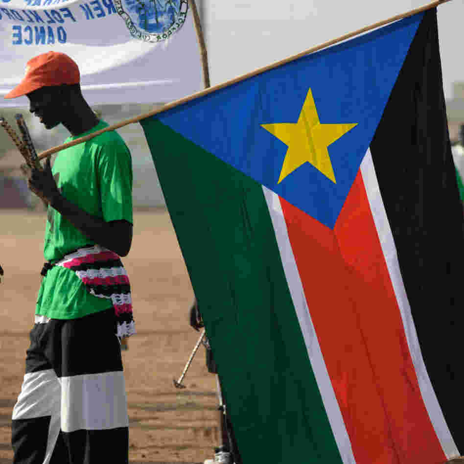 A Sudanese man holds the flag of South Sudan.