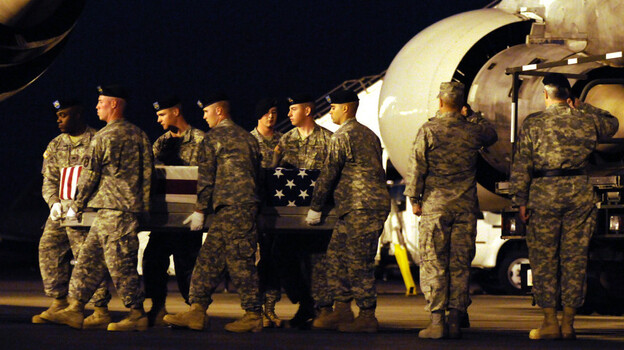 An Army team carries a transfer case containing the remains of Army Pvt. Keiffer P. Wilhelm at Dover Air Force Base, Del., in 2009. The Ohio soldier committed suicide in Iraq after allegedly being harassed by other men in his platoon.