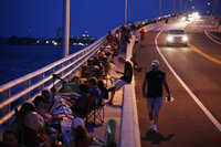 People line a bridge in Titusville, Fla., early Friday morning, making use of a different vantage point on the launch.