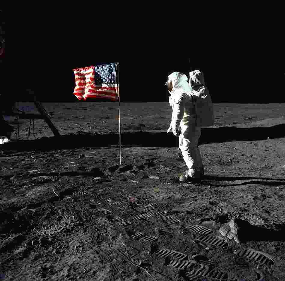 Astronaut Edwin (Buzz) E. Aldrin Jr., pilot of the Apollo 11 mission, poses beside a flag on the surface of the moon. One space policy analyst says the space shuttle program was the natural successor to the Mercury, Gemini and Apollo programs and evolved humans' ability to live and work in space.