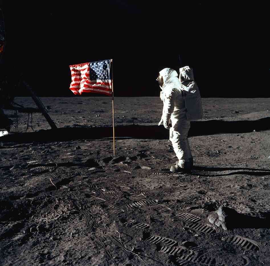 Astronaut Edwin (Buzz) E. Aldrin Jr., pilot of the Apollo 11 mission, poses beside a flag on the surface of the moon. One space policy analyst says the space shuttle program was the natural successor to the Mercury, Gemini and Apollo programs and evolved humans' ability to live and work in space.