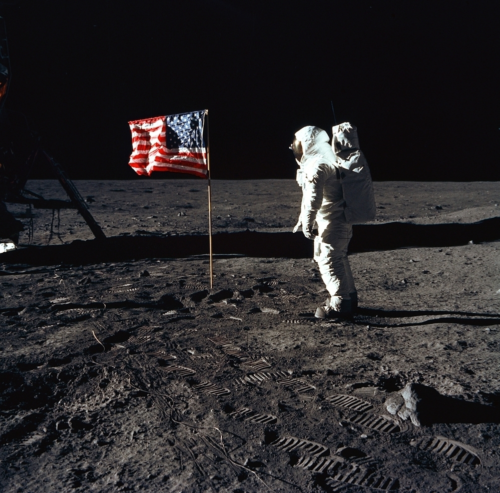 Astronaut Edwin (Buzz) E. Aldrin Jr., pilot of the Apollo 11 mission, poses beside a flag on the surface of the moon. One space policy analyst says the space shuttle program was the natural successor to the Mercury, Gemini and Apollo programs and evolved humans' ability to live and work in space.