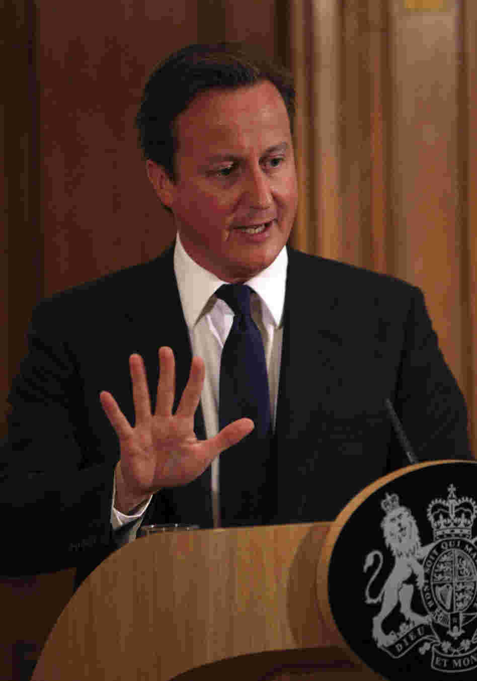 Britain's Prime Minister David Cameron promises a full investigation into the phone hacking and police bribery scandal that led to the collapse of the News of the World tabloid, at a press conference in London on Friday.