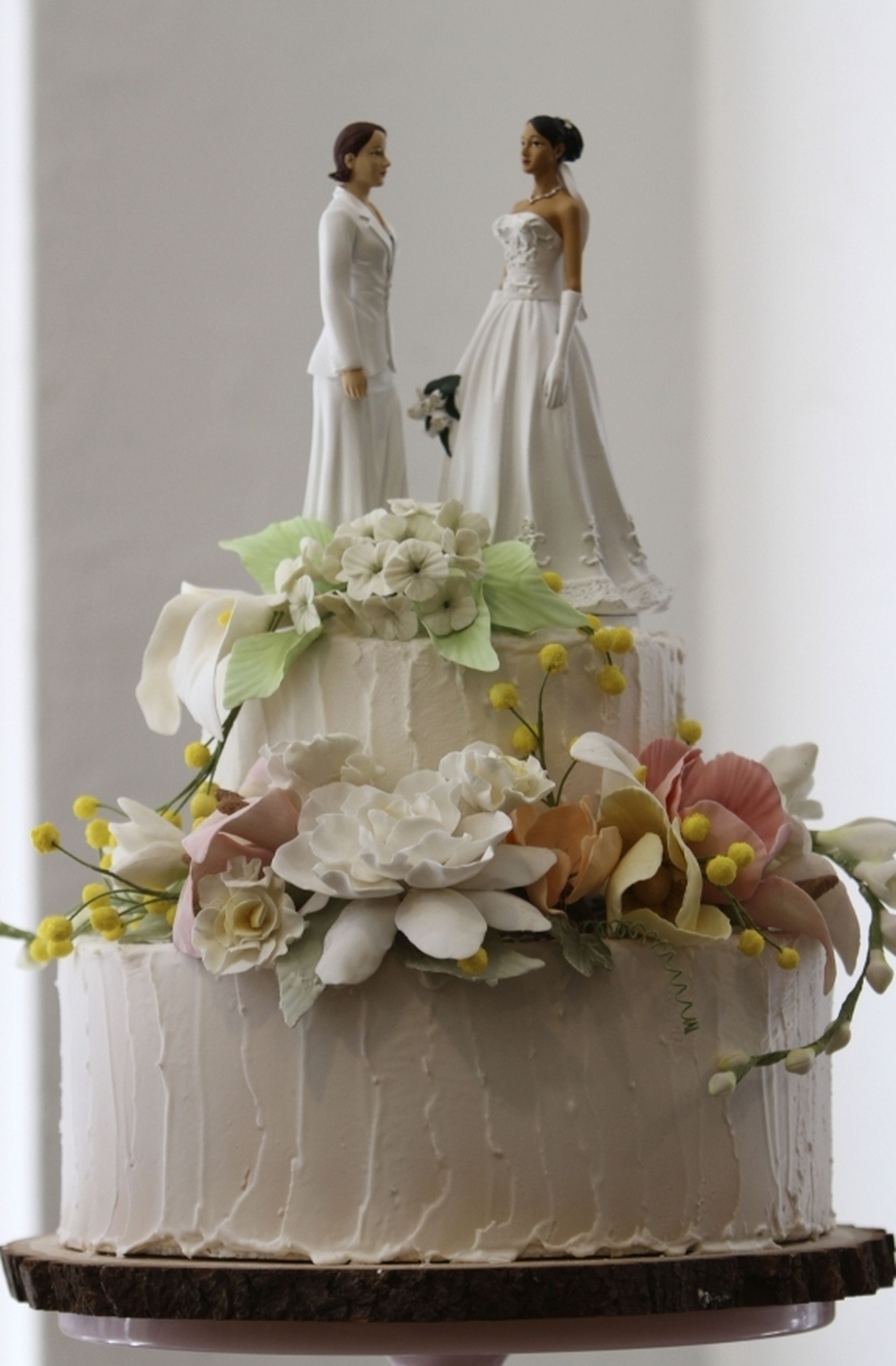 Two female figurines stand atop a wedding cake on display in a New York bakery. Lesbian couples are twice as likely to marry as gay couples, UCLA demographer Gary Gates says.