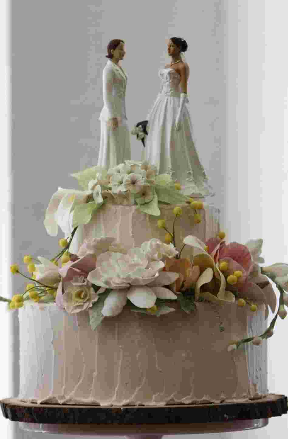 Two female figurines stand atop a wedding cake on display in a New York bakery. Lesbian couples are twice as likely to marry as gay couples, UCLA demographer Gary Gates says.