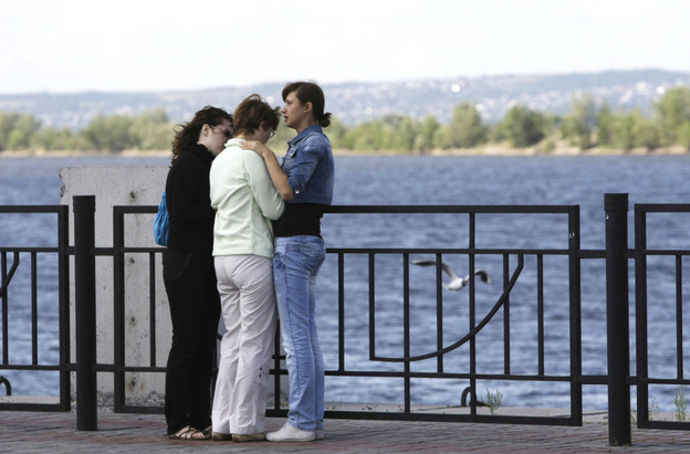 Relatives of passengers believed to be aboard a cruise ship that sank on the Volga River await fresh information at a river station in Kazan, about 450 miles east of Moscow on Monday. More than a dozen had been confirmed dead Monday morning, and more than 100 remained missing.