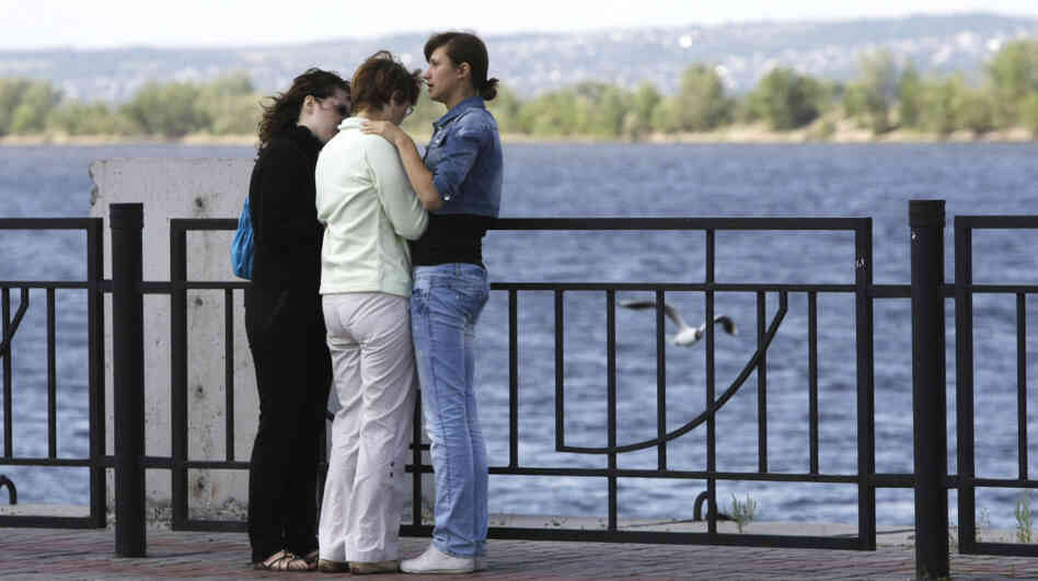 Relatives of passengers believed to be aboard a cruise ship that sank on the Volga River await fresh information at a river station in Kazan, about 450 miles east of Moscow on Monday. More than a dozen had been confirmed dead Monday morning, and more than 100 remained missing.