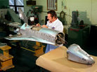 A worker tests components on a model of the space shuttle before wind tunnel testing. A worker tests components on a model of the space shuttle before wind tunnel testing.