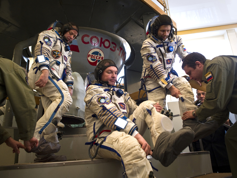 Crew members of the International Space Station — (from left) U.S. astronaut Ron Garan and Russian cosmonauts Alexander Samokutyaev and Andrei Borisenko — prepare to enter a Soyuz simulator outside Moscow on March 30. With the space shuttle program out of commission, the Russian Soyuz vehicle will be the only way for Americans to reach space.