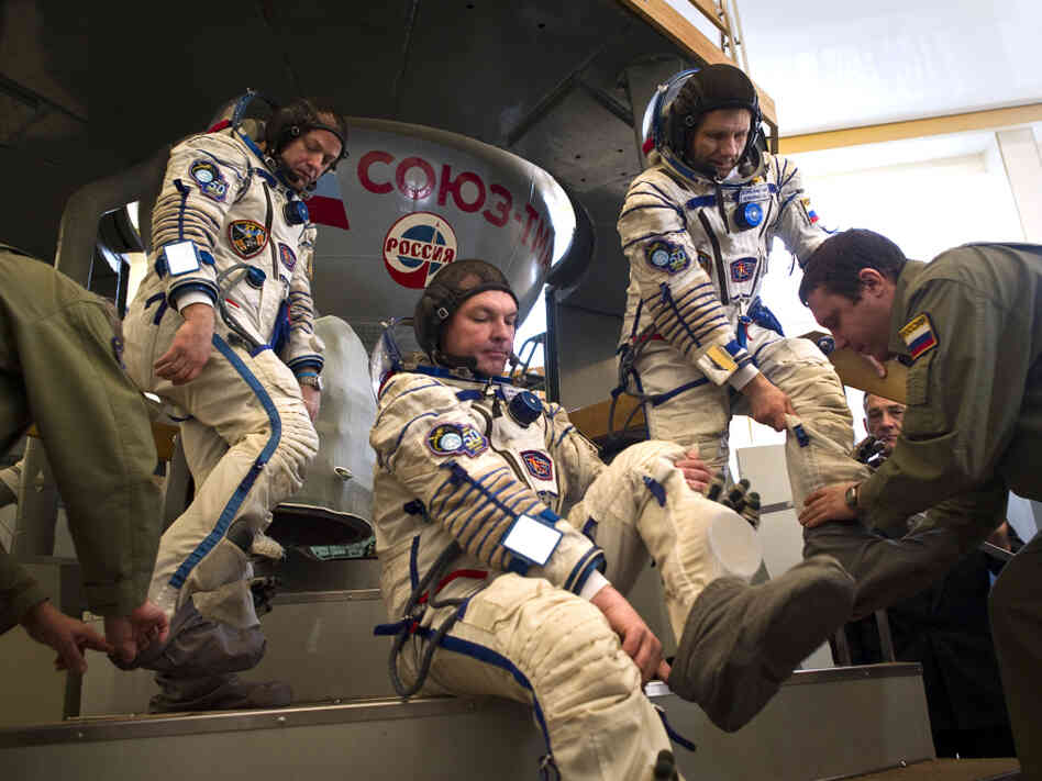 Crew members of the International Space Station — (from left) U.S. astronaut Ron Garan and Russian cosmonauts Alexander Samokutyaev and Andrei Borisenko — prepare to enter a Soyuz simulator outside Moscow on March 30. With the space shuttle program out of commission, the Russian Soyuz vehicle will be the only way for Americans to reach space.