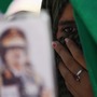 In this photo taken on a government-organized tour, a Libyan student holds a portrait of Libyan leader Moammar Gadhafi in Tripoli, Libya. The government has many die-hard supporters in the capital, but pockets of opposition can be found.
