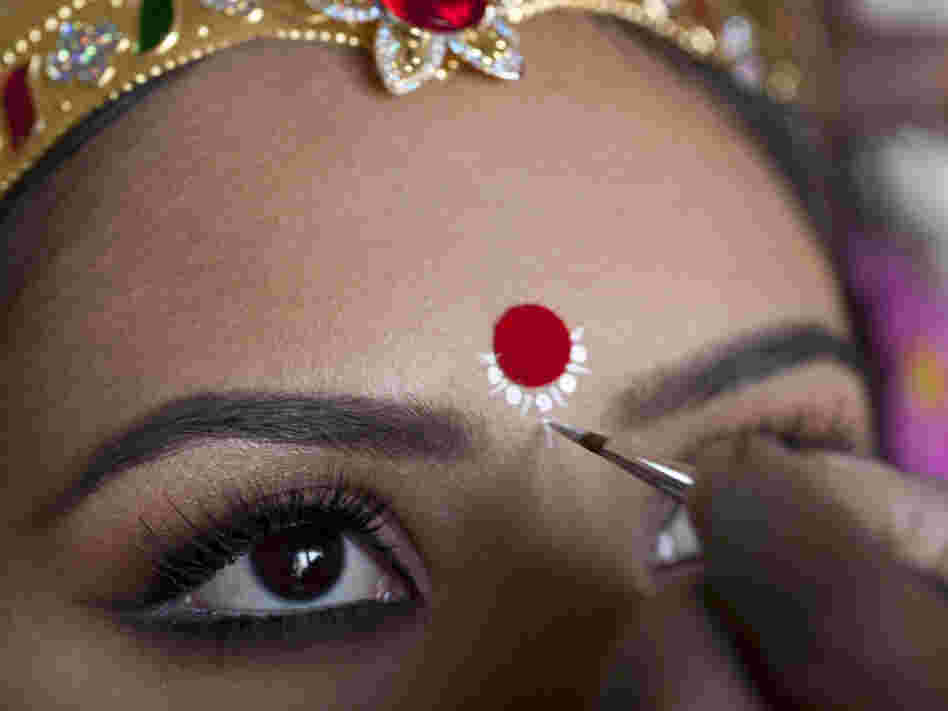 A make-up artist studied and painted the features of Maa  Laxmi's eyes and ornamental touches.