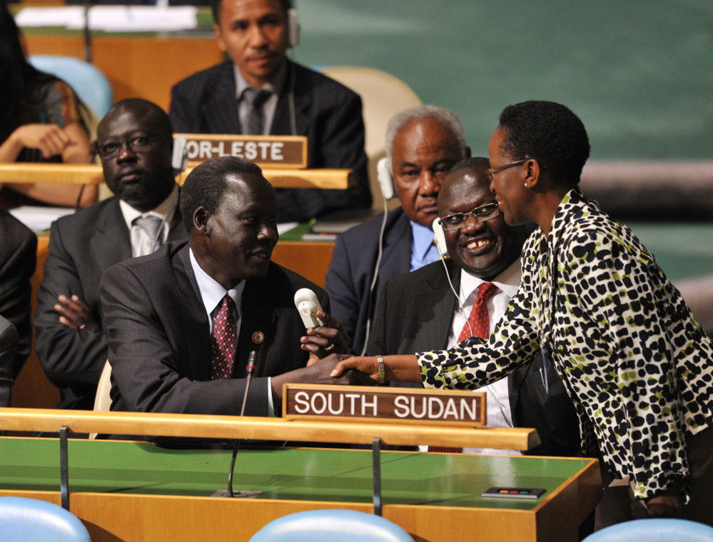 The South Sudan delegation, including Vice-President Riek Machar Teny-Dhurgon (second from right), are congratulated by a delegate as they take their seats after the U.N. General Assembly voted to admit the newly formed nation.