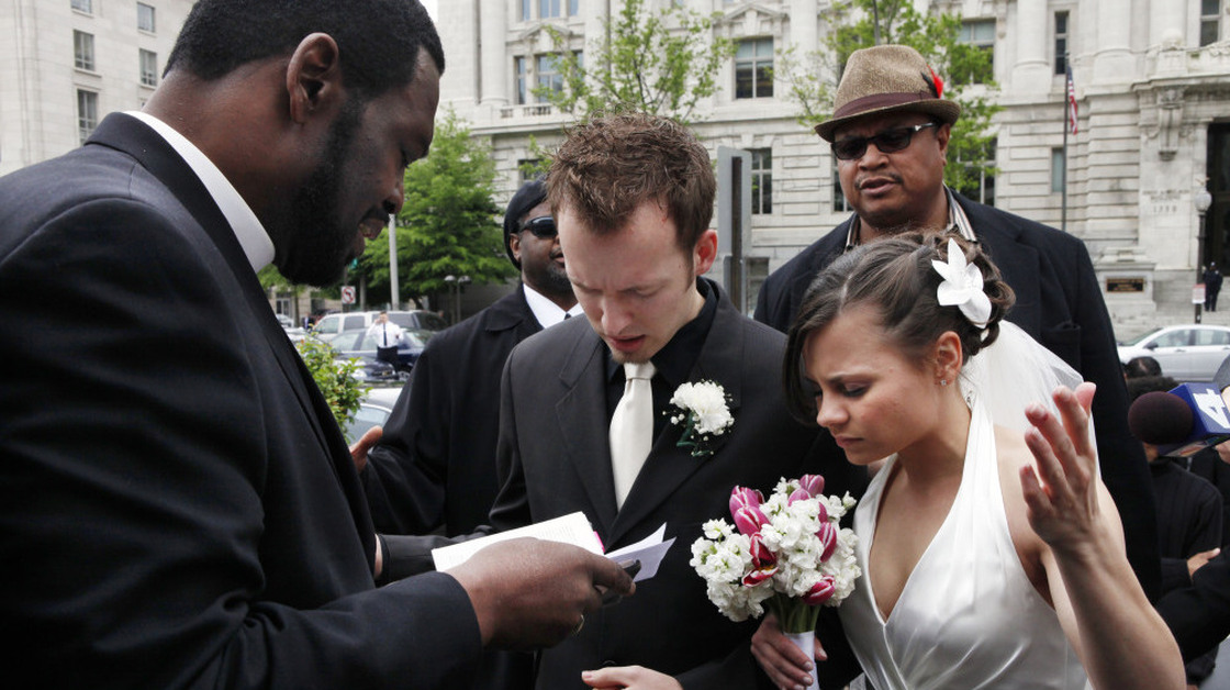 Bishop Harry R. Jackson Jr., left, prays with Jonathan Paul Ganucheau and Denise Buckbinder Ganucheau before performing a religious wedding ceremony that was part of a protest against the District of Columbia city council's approval of legislation recognizing same sex marriages performed in other states, in Washington, on Tuesday, May 5, 2009.