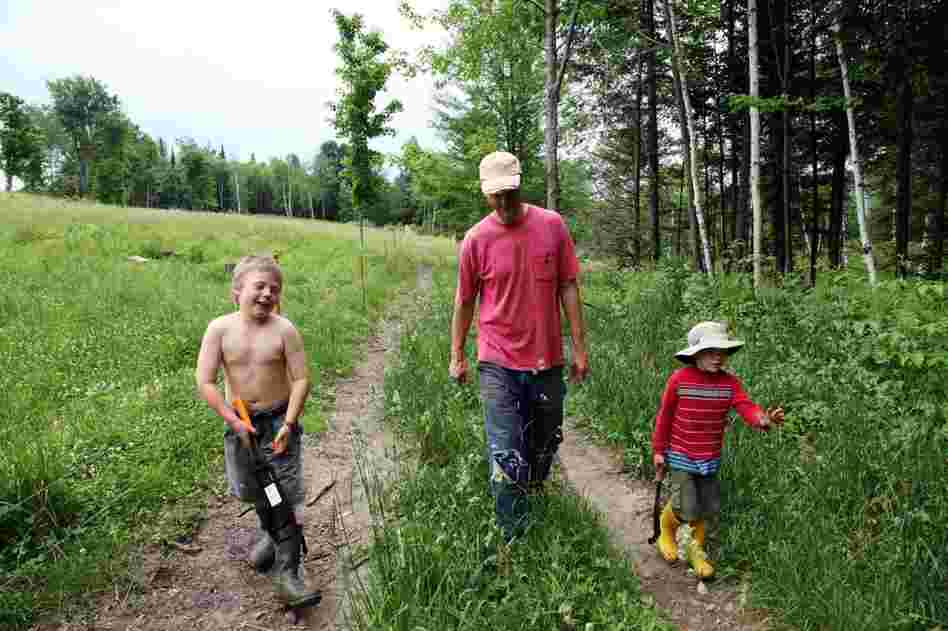 The Hewitt boys, Fin (left) and Rye (right), walk with their father on the family farm. Hewitt is a back-to-the land activist who helped put Hardwick's local food scene on the map.