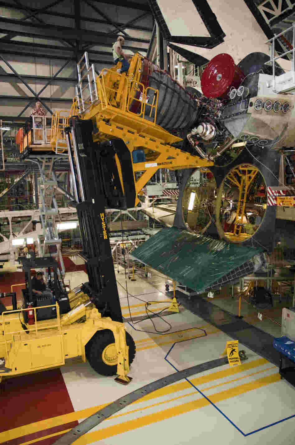An engine is removed from space shuttle Endeavour after its final mission. Lookalike engines will replace the real ones when the shuttles go on display.