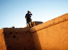 Afghan National Army soldier Mohammed Shadwar gets a bird's-eye view from the rooftop of a mud-walled compound during a joint clearing operation in Helmand province, Afghanistan. As the top U.S. commander in Afghanistan changes, there's a question of whether U.S. policy will shift from one that supports building up Afghan national security forces to one focused on targeting insurgents. Afghan National Army soldier Mohammed Shadwar gets a bird's-eye view from the rooftop of a mud-walled compound during a joint clearing operation in Helmand province, Afghanistan. As the top U.S. commander in Afghanistan changes, there's a question of whether U.S. policy will shift from one that supports building up Afghan national security forces to one focused on targeting insurgents.