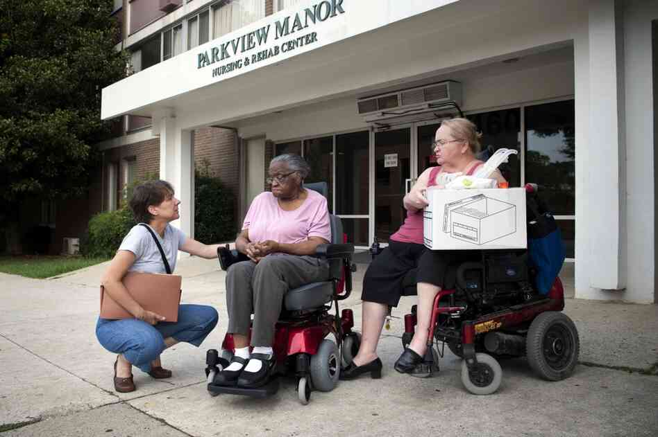 Hendrix waits for transportation to her new apartment with Toni Pastore, a paralegal from Atlanta Legal Aid Society, who organized her relocation (left), and Cheryl Laurendeau, her peer supporter.
