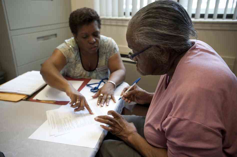 Selena Rambert, manager for Capitol Avenue Apartments, goes over paperwork with Hendrix before she moves into the apartment that will be her new home.